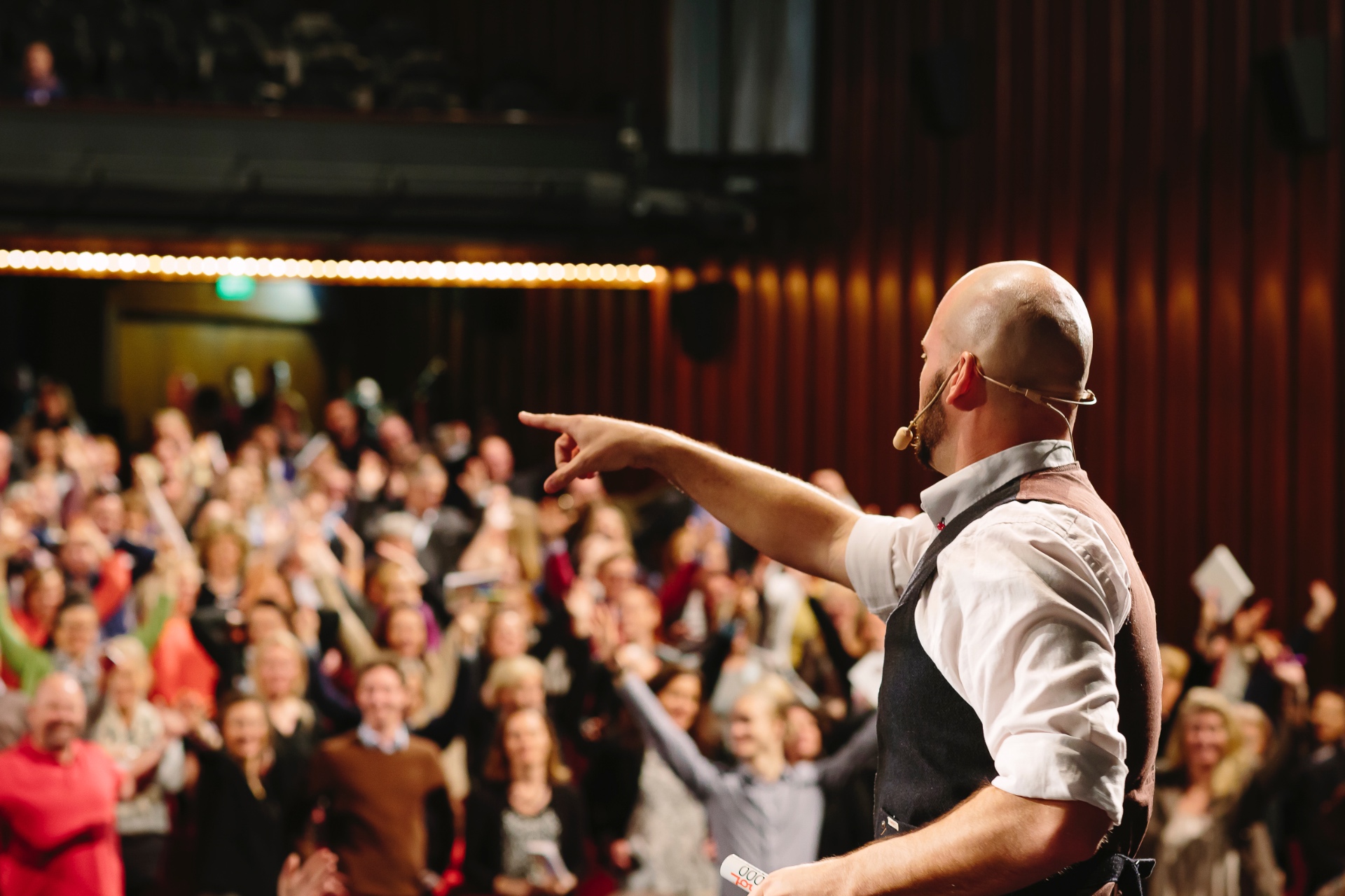 Alex pointing into a packed, energised audience